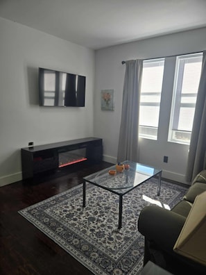 TV, fireplace, DVD player, books - 🛋️ Cozy Meets Contemporary Modern one bedroom with Fireplace & Smart TV – The Gratiot (Detroit)