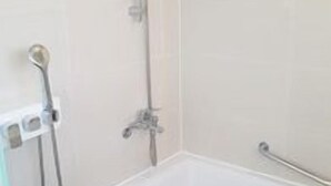 A bathroom with a bathtub, a showerhead, and a handheld shower attachment. - Amid Hotel Seoul (Seoul)