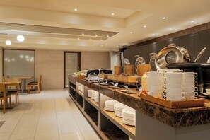 A modern hotel breakfast area with a marble counter, dining tables, and a variety of breakfast items. - Amid Hotel Seoul (Seoul)