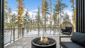 A balcony with a fire pit, a chair, and a sofa. - Off Grid Stays - Treehouse #4 (Columbia Falls)