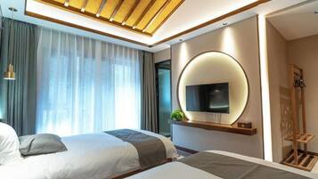 Una habitación de hotel moderna con dos camas, un televisor grande montado en la pared y un techo con listones de madera.