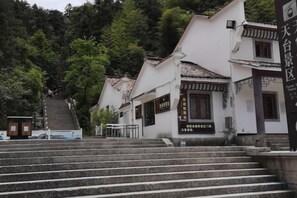 Un bâtiment traditionnel japonais avec un escalier menant à l’entrée.