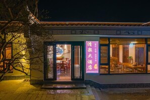 Un edificio de estilo arquitectónico tradicional, con tejado de baldosas y una entrada bien iluminada.