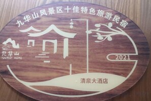A wooden plaque with Chinese characters, a mountain graphic, and the year 2021. - Jiu Hua Qing Quan Hotel (Qingyang)
