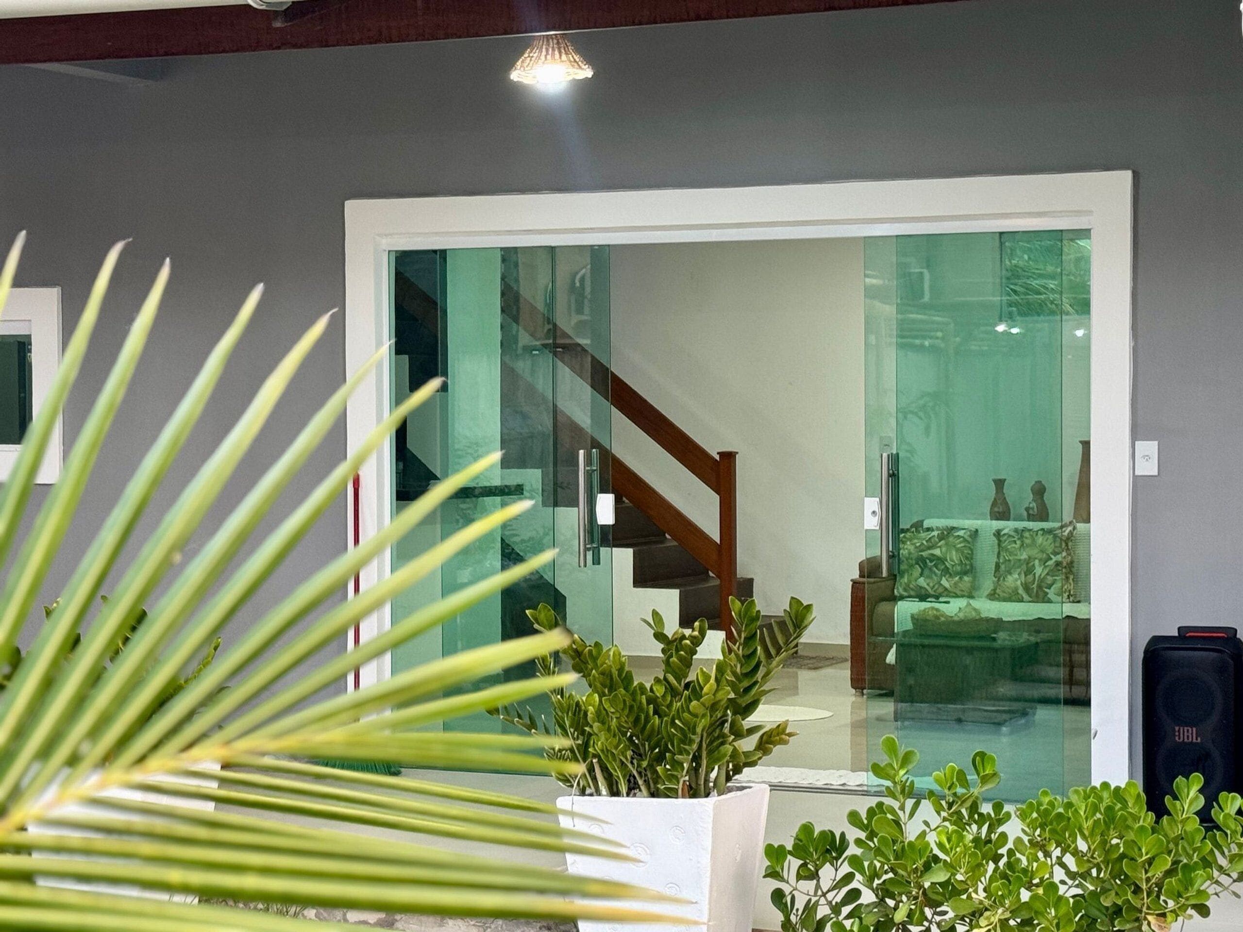 Un intérieur moderne avec un escalier, des portes vitrées et des plantes d’intérieur.
