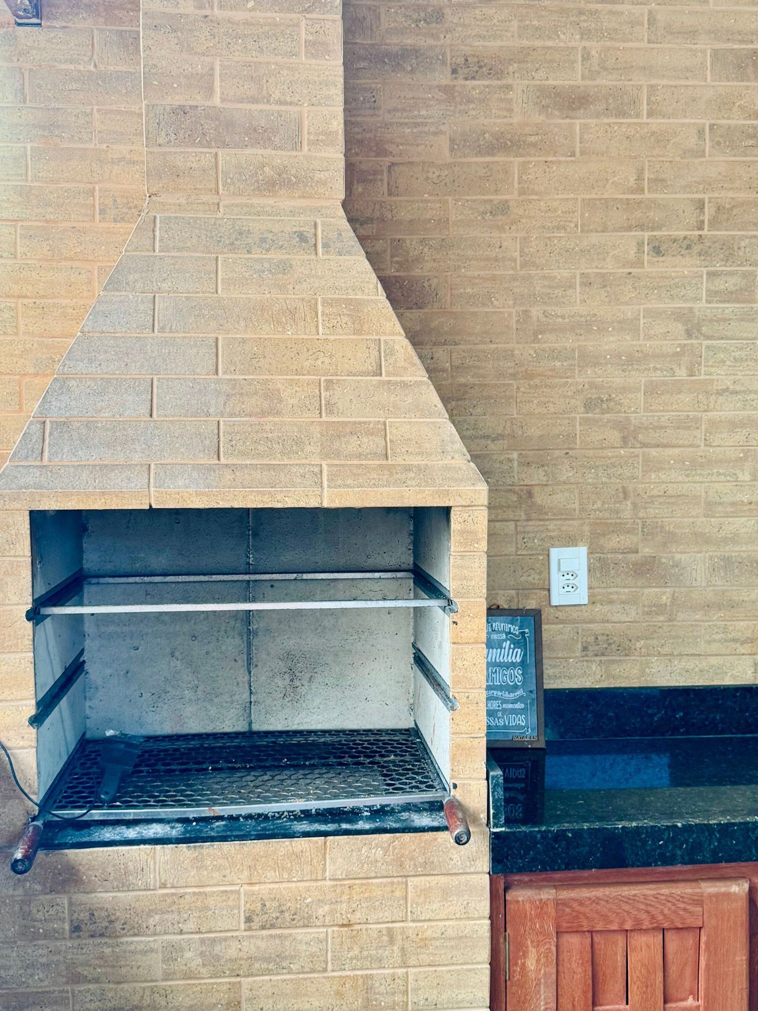 A brick oven with shelves, a metal rack, and a wooden bench.