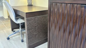 A modern dining area with a dark wooden table, a patterned chair, and a decorative lamp.