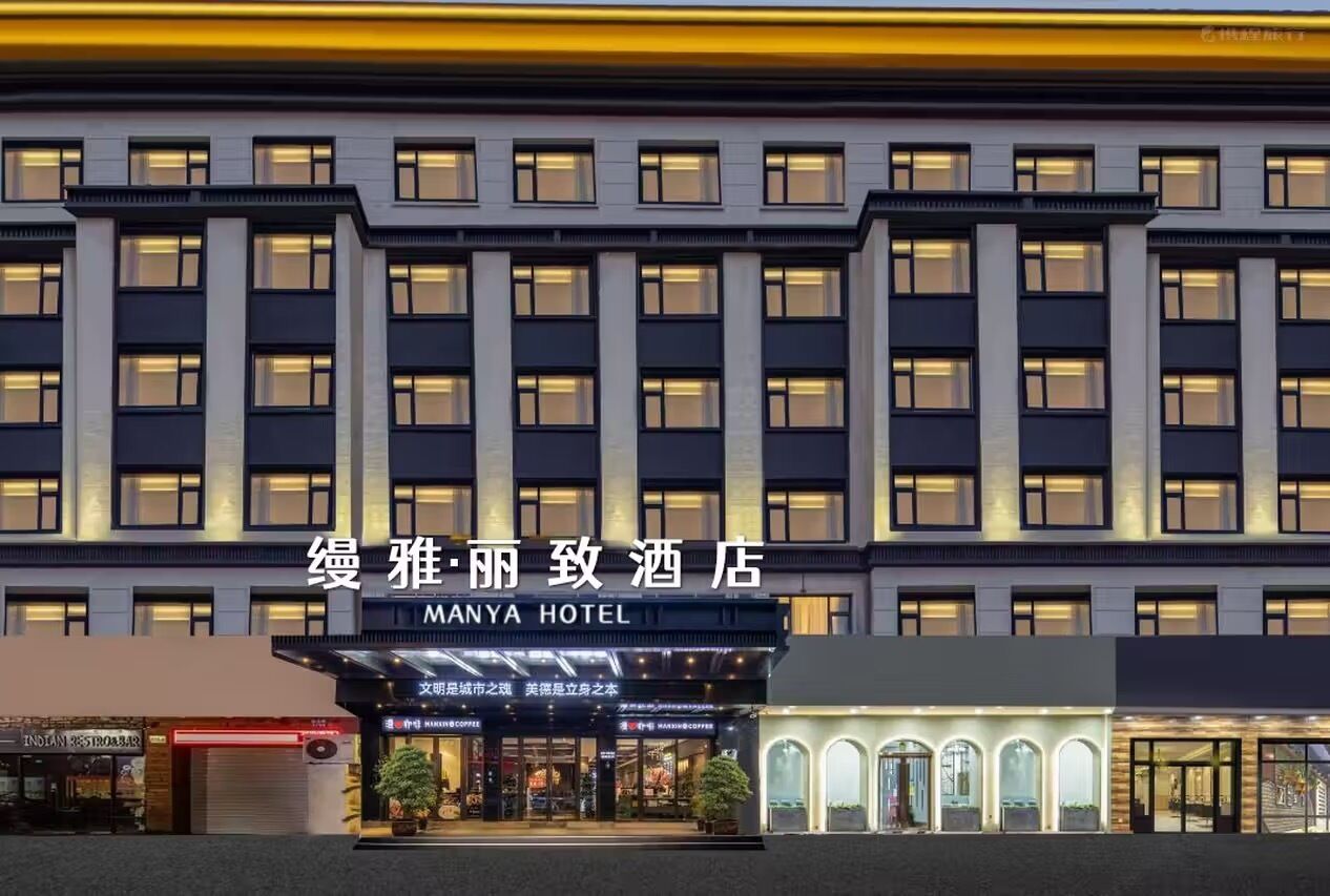 A multi-story hotel with a modern facade, featuring a prominent entrance with illuminated signage.