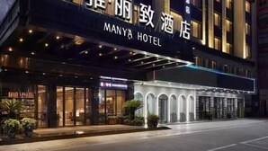 Un hotel con facciata moderna, insegne illuminate e ingresso ben illuminato.