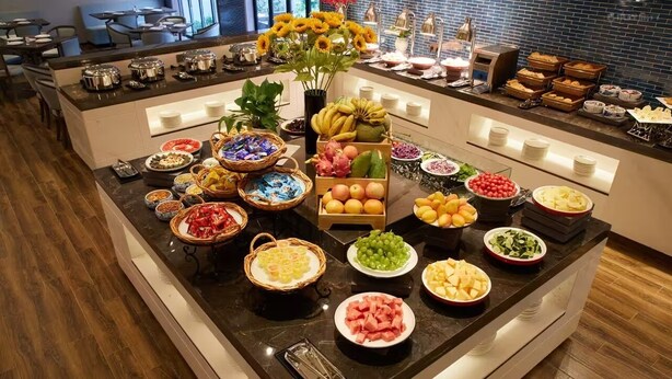 Un buffet con diversi cibi e un vaso di girasoli.