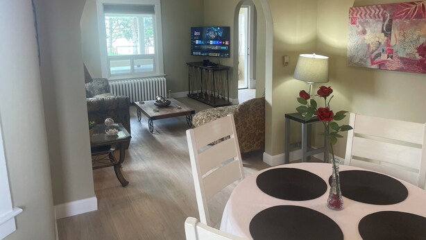 A living room with a television, a dining table with placemats, and a painting on the wall. - Ultra Close to the Falls (Niagara Falls)