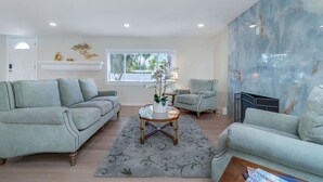 A spacious living room with two light grey sofas, a round coffee table, and a decorative plant centerpiece. - Hey! I Am Adriana On The Block | Pool | BBQ (Mission Viejo)