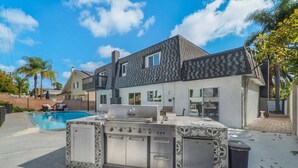 A modern house with a large backyard, a swimming pool, and a built-in outdoor kitchen. - Hey! I Am Adriana On The Block | Pool | BBQ (Mission Viejo)