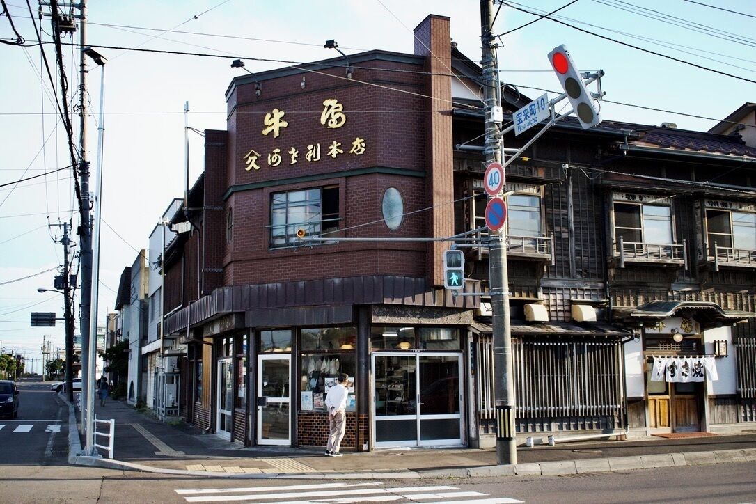 A traditional Japanese building with a sign reading "Cow House" and "Sake Bar".