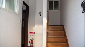 A staircase with wooden steps leading to a landing. - THE HORAI (Hakodate)