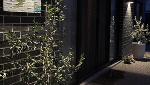 A brick building with a sign reading "MARSASKALA" and potted plants along the pathway.