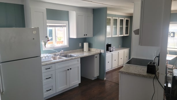 A kitchen with white cabinets, a granite countertop, a refrigerator, and a coffee maker. - Explore the Owyhee River, Leslie's gultch,  Three Forks, lava tubes and more. (Jordan Valley)