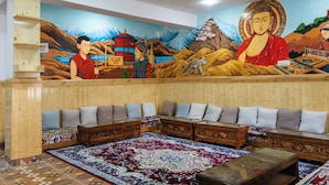 A traditional room with a mural, wooden furniture, and a patterned carpet. - Story Homes (Kaza)