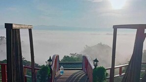 A wooden bridge leading to a high viewpoint with a clear view of the landscape and distant mountains. - Mirinja Valley Megh Machang Resort (Lama)
