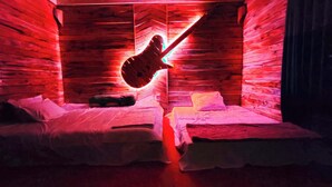 A room with two beds, wooden walls, and a guitar hanging on the wall. - Mirinja Valley Megh Machang Resort (Lama)
