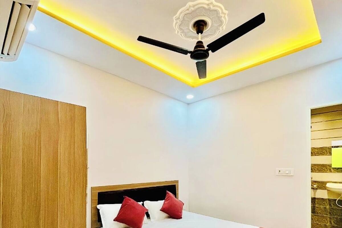 Ein Hotelzimmer mit einem Bett, einem Deckenventilator und einem Holzschrank.