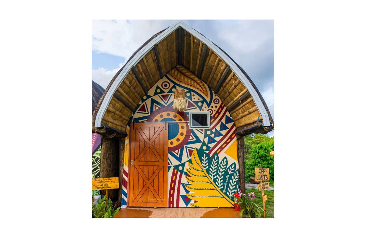Un edificio colorido y decorado artísticamente, con una puerta de madera y un letrero que indica 'OFF LIMITS'.