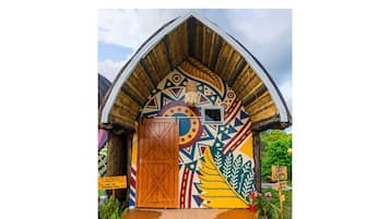 Um edifício colorido e artisticamente decorado com uma porta de madeira e uma placa indicando 'OFF LIMITS'.
