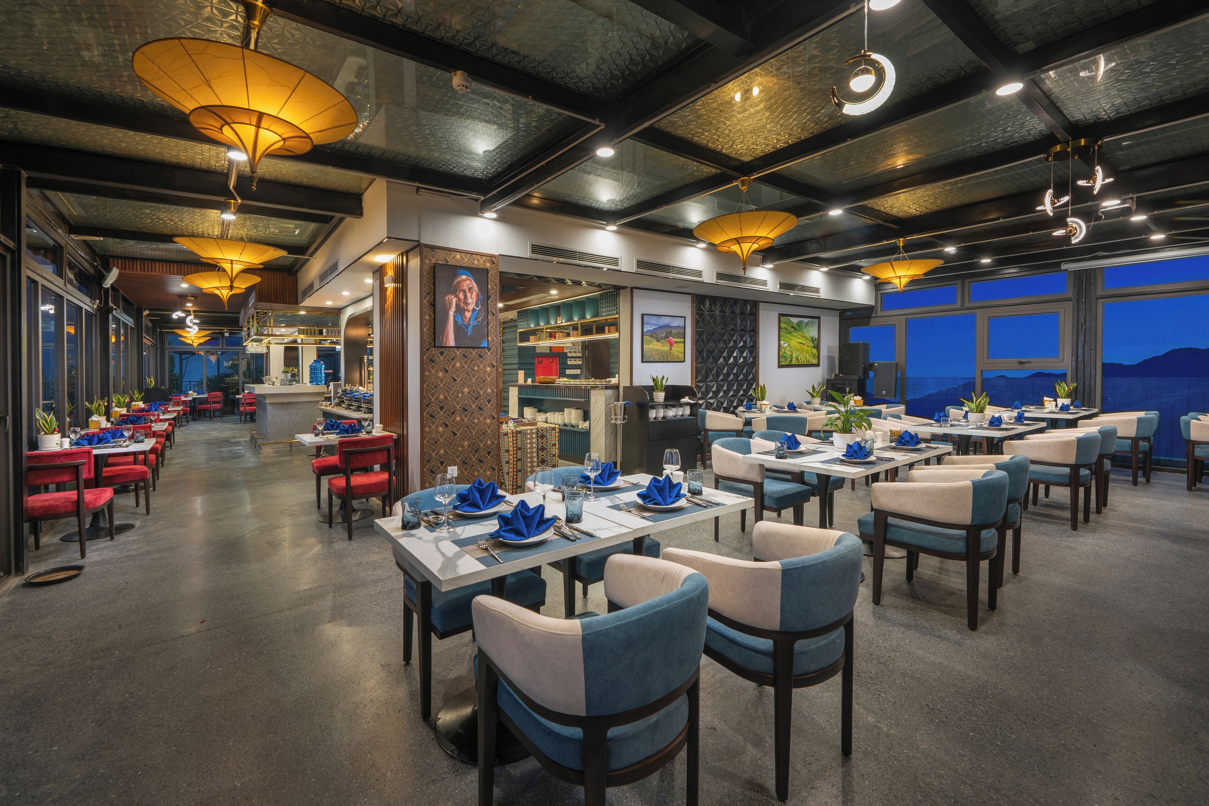 A restaurant with tables and chairs, a bar area, and a view of the mountains.