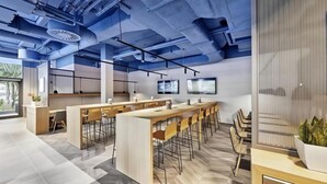 A modern office space with long tables, chairs, and a large screen on the wall. - Sunday Düsseldorf Seestern (Dusseldorf)