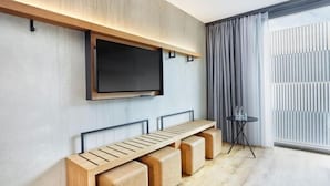 A modern living room with a built-in TV, a wooden bench, and a small table. - Sunday Düsseldorf Seestern (Dusseldorf)
