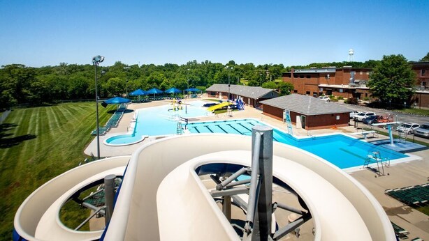 Un parc aquatique doté de plusieurs toboggans, d’une piscine et d’un bâtiment à toit plat.