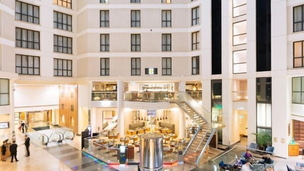A multi-level hotel lobby with a central atrium, multiple floors, and a staircase. - Sofitel London Gatwick (Horley)