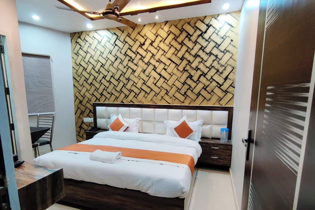 A modern bedroom with a bed, bedside tables, a ceiling fan, and a patterned wall.