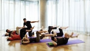 A group of people on yoga mats in a room with large windows and a high ceiling. - Sheraton Grand Hotel & Spa, Edinburgh (Edinburgh)