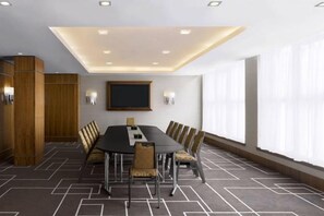 A conference room with a long table, chairs, a flat-screen TV, and a patterned carpet. - Sheraton Grand Hotel & Spa (Edinburgh)