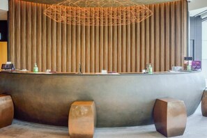 A reception area with a curved desk, a vertical striped curtain, and a geometric light fixture. - Solaria Nishitetsu Hotel Seoul Myeongdong (Seoul)