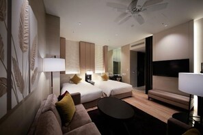 A hotel room with two beds, a sofa, a coffee table, a TV, and a ceiling fan. - Solaria Nishitetsu Hotel Seoul Myeongdong (Seoul)