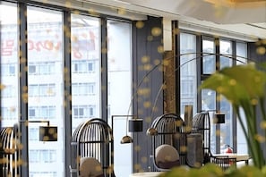 Ein modernes Interieur mit großen Fenstern, Stühlen in Vogelkäfigform und einem minimalistischen Design.