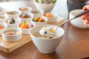 Pequeños recipientes con distintos alimentos sobre una tabla de madera.