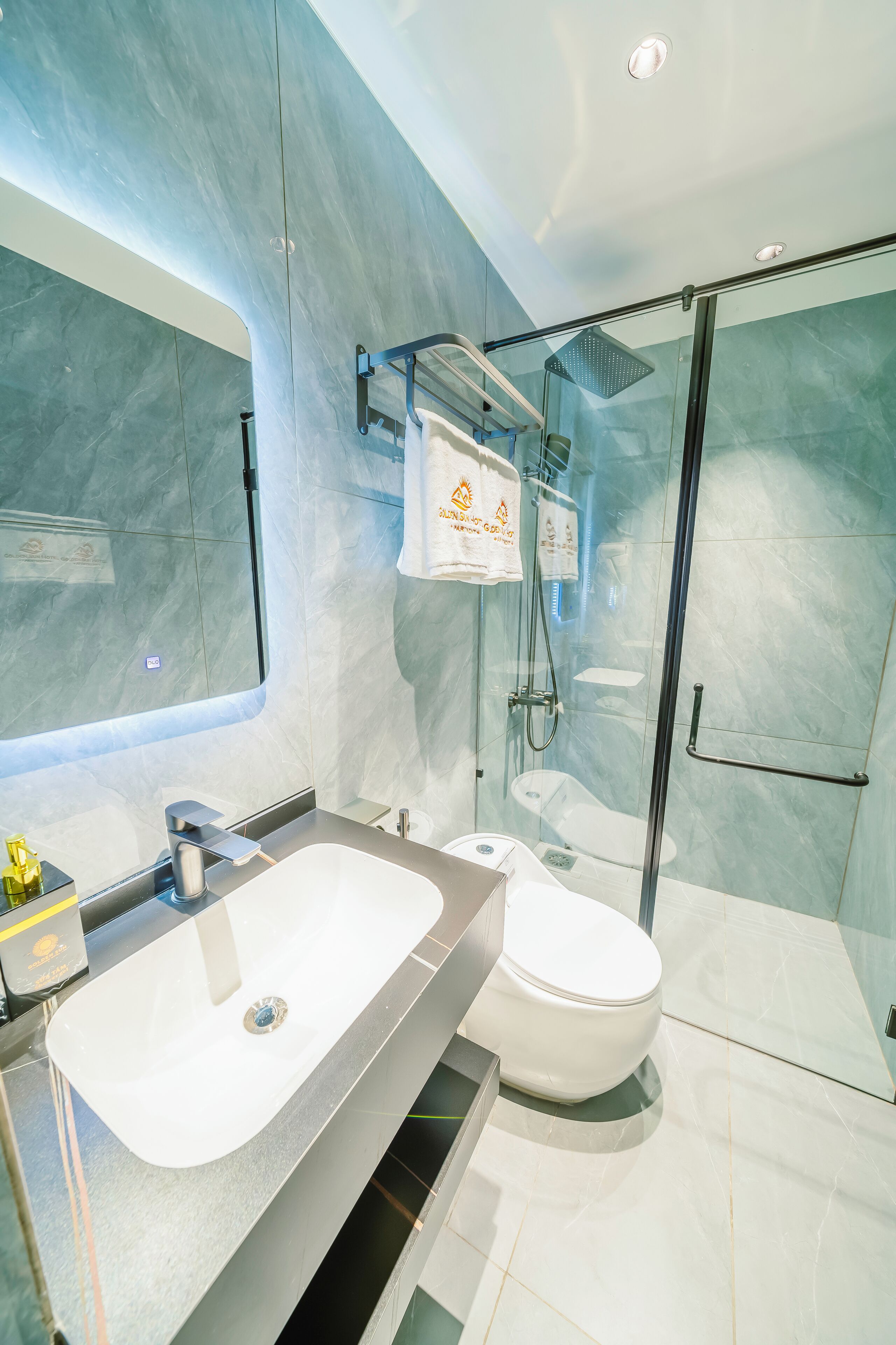 A modern bathroom with a glass-enclosed shower, a white sink, and a toilet.
