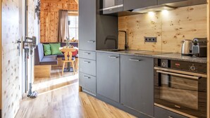 Een moderne keuken met grijze kastjes, een Siemens oven en een houten wand.