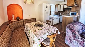 A cozy dining area with a wooden bench and a table covered with a floral tablecloth. - Hochstuhlblick by Interhome (Ludmannsdorf)
