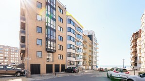 A multi-story residential building with a modern design, featuring balconies and large windows.