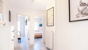 A hallway with a bed, a radiator, and a framed picture on the wall. - Renovated flat centrally located (Koksijde)
