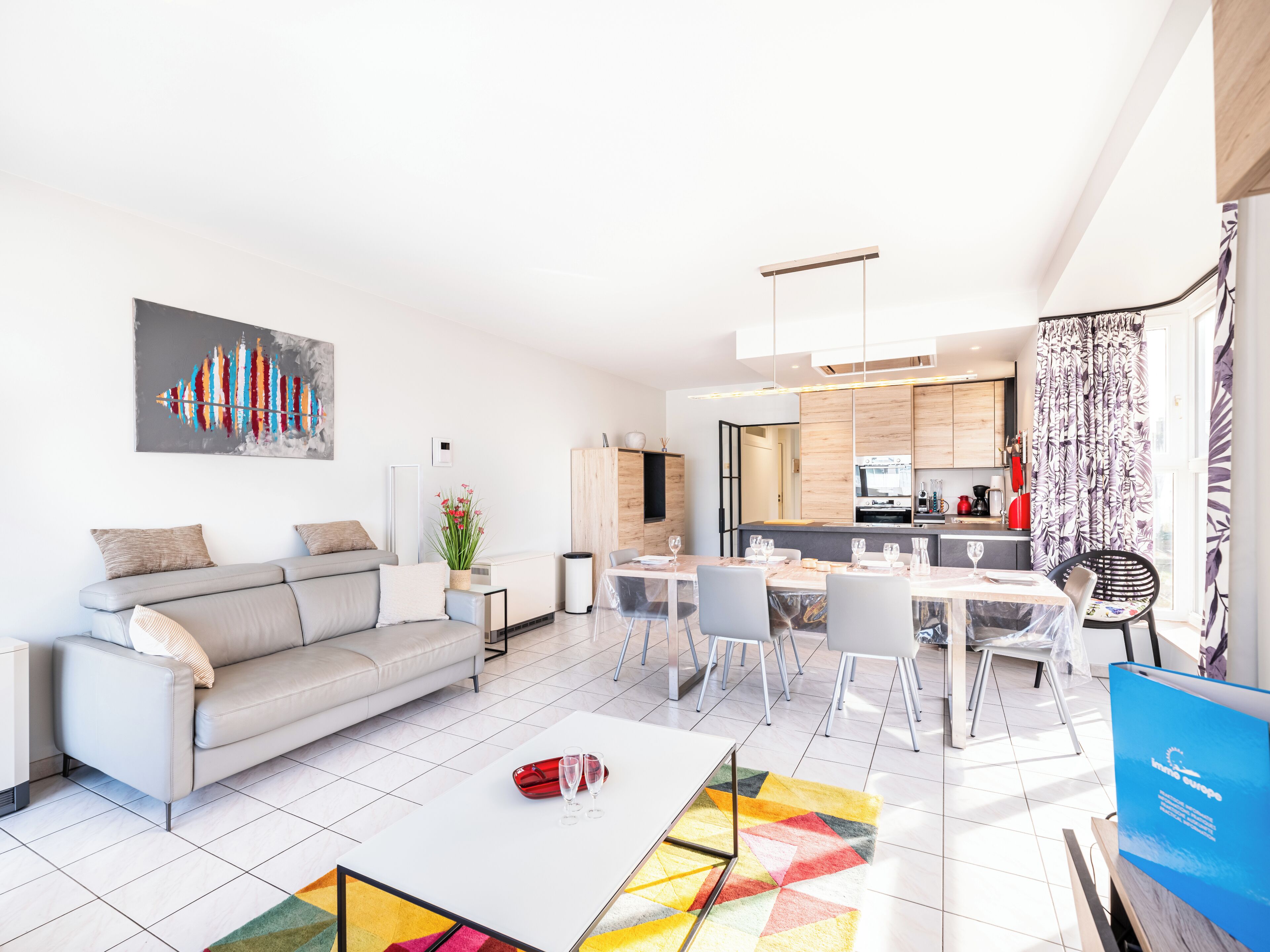 Una sala moderna con sofá, mesa de centro y comedor.