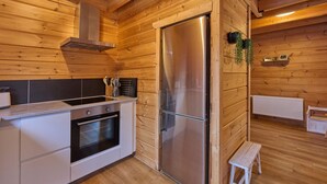 Una cocina moderna con paredes de madera, electrodomésticos de acero inoxidable y un taburete de madera.