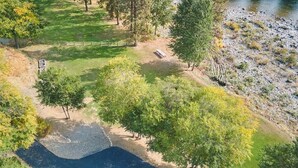 Vista aérea de un parque con un camino de grava, árboles y un banco.