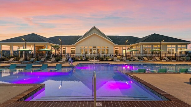 A hotel with a large pool, lounge chairs, and umbrellas. - Landing Apartments - Lebanon, IN (Lebanon)