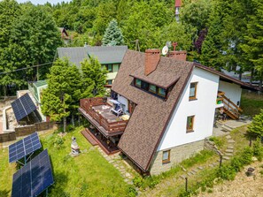 A two-story house with a sloped roof, a balcony, and solar panels. - Beautiful apartment for 6 people with WIFI, TV, patio and pets allowed (Wilkowski)