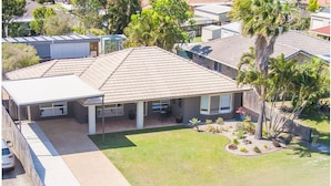 A residential house with a tiled roof, a front porch, and a well-maintained lawn. - Stays with Ripley,
4bed, 2 bath pet friendly home only 3min drive to Hosp/beach! (Urraween)